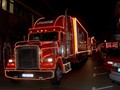 Die fünf beleuchteten Coca-Cola Weihnachtstrucks fahren langsam ...
